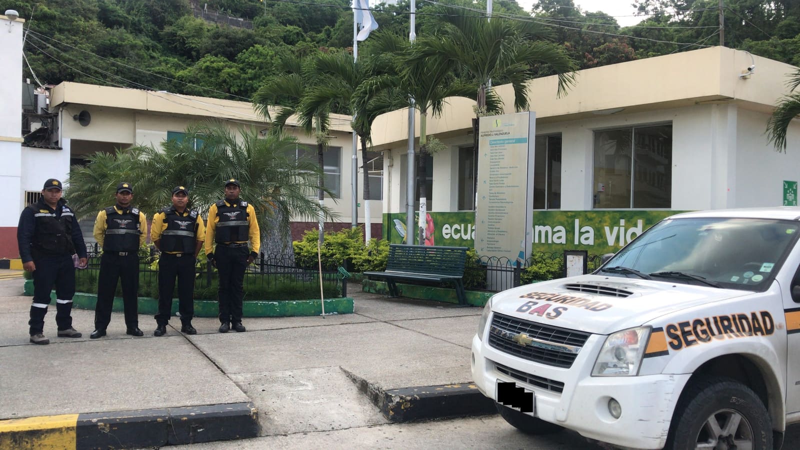 Técnico revisando un grabador y el panel de alarma de una instalación